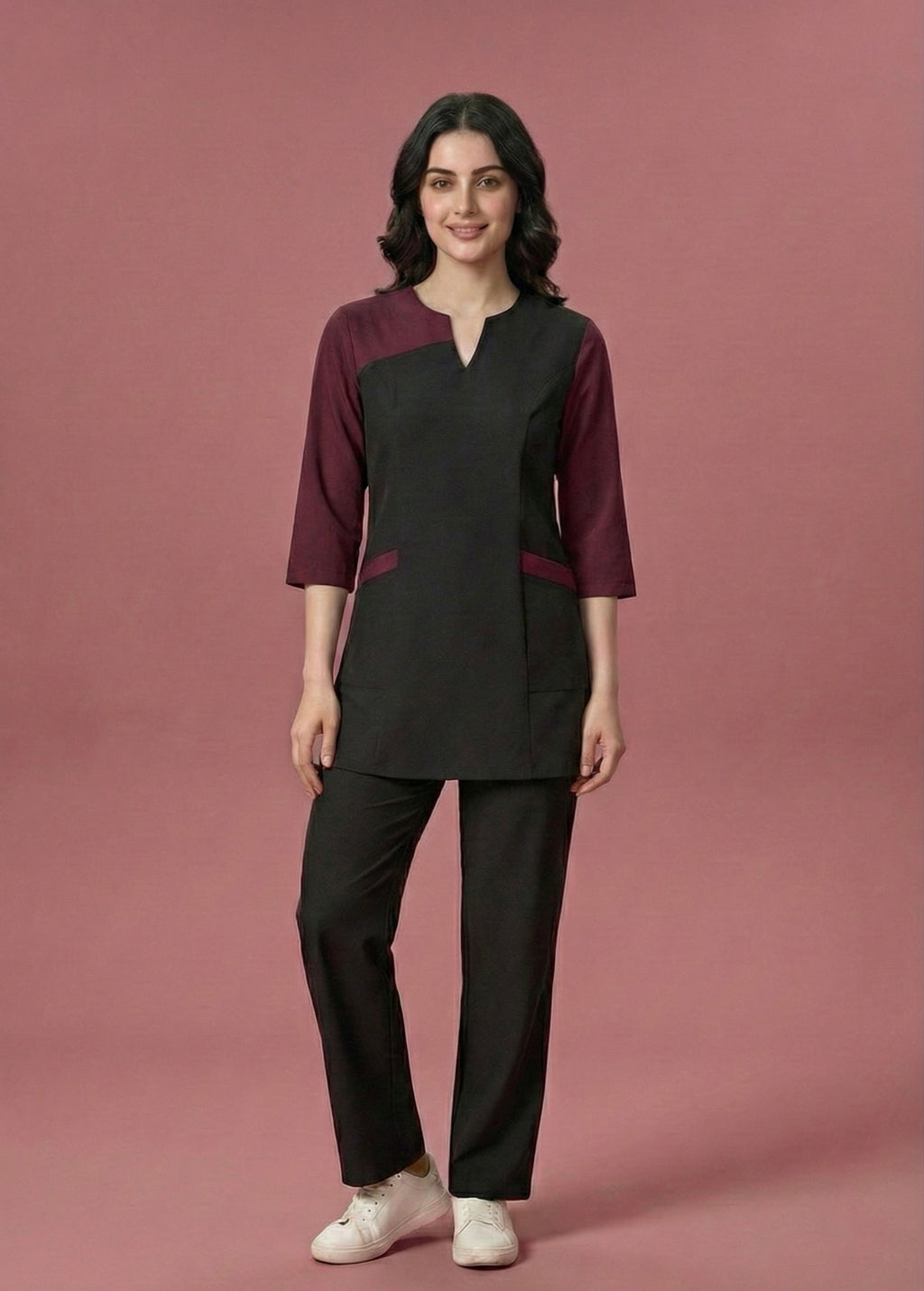 Woman wearing a black and burgundy outfit on a pink background