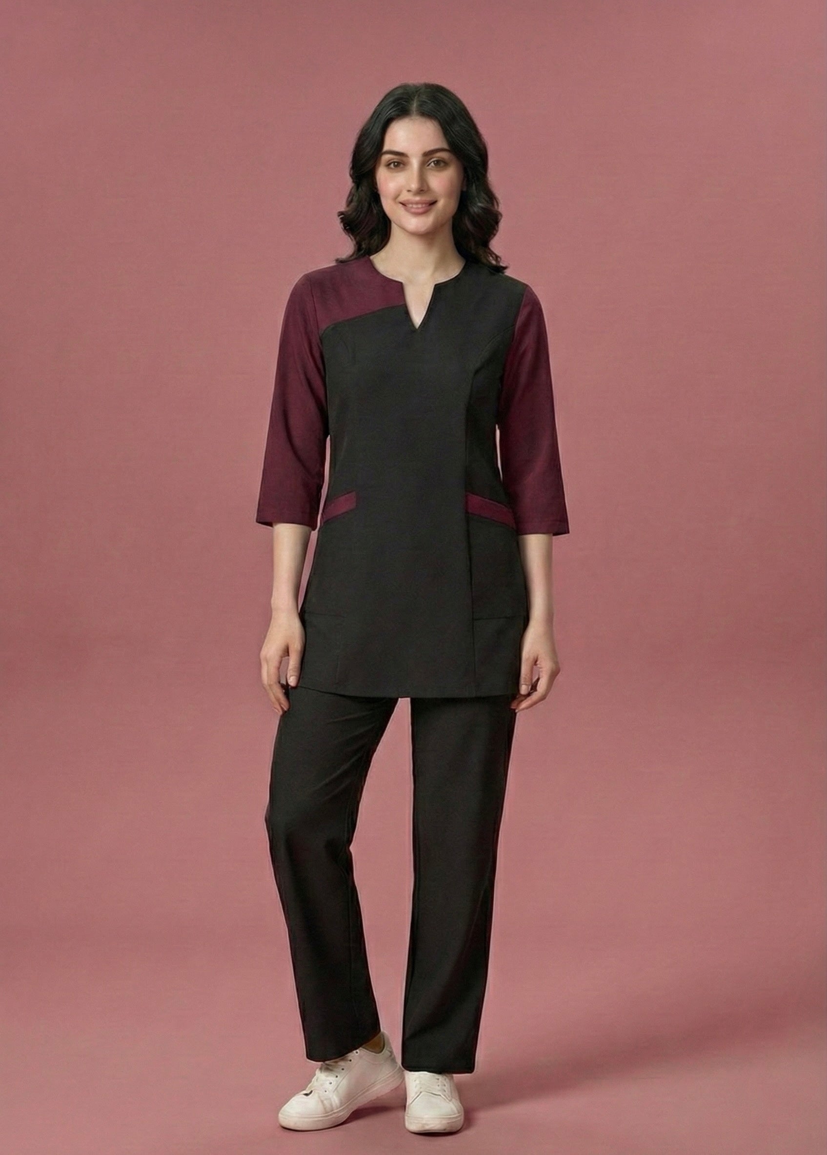 Woman wearing a black and burgundy outfit on a pink background