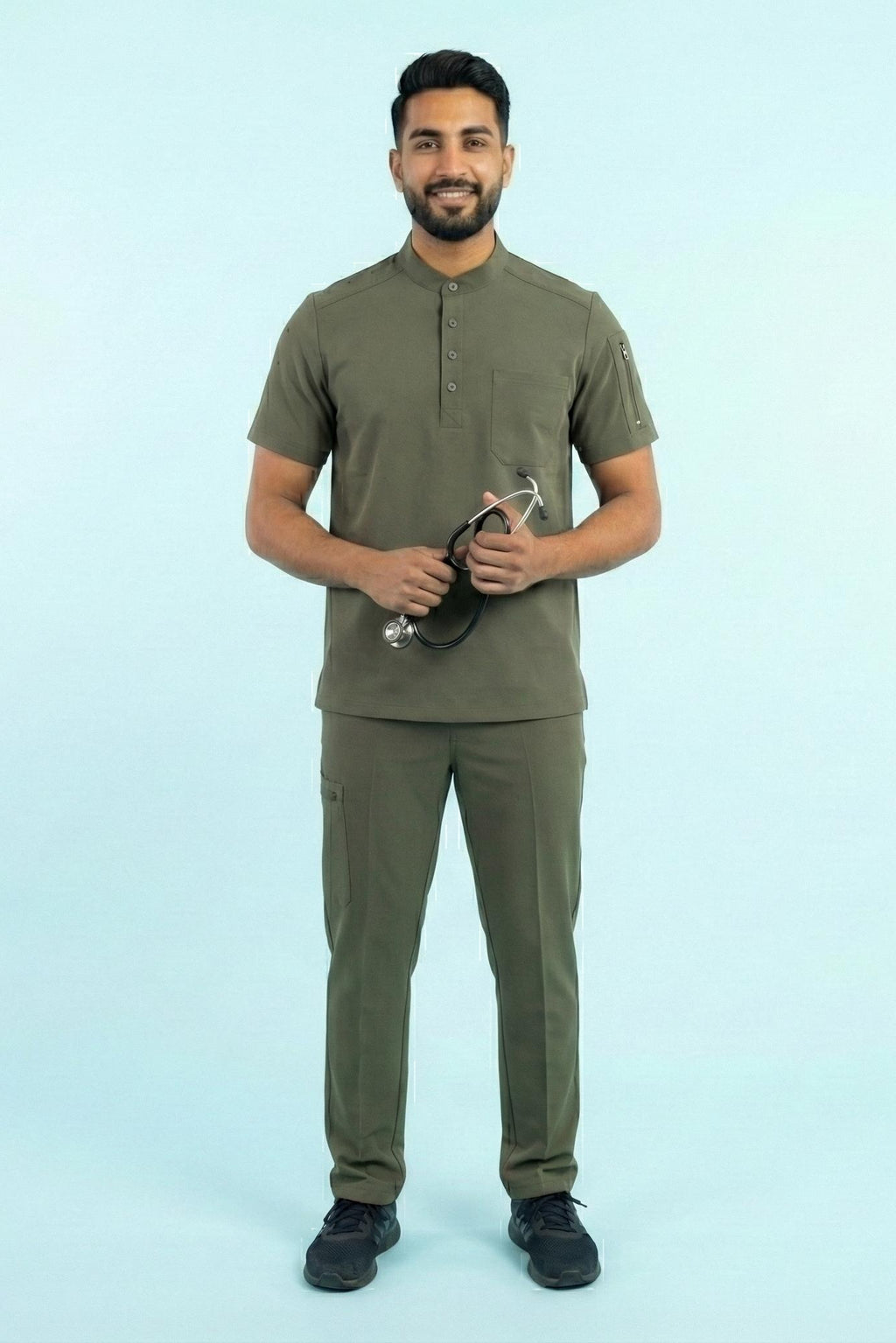 Man wearing a green outfit holding a stethoscope against a light blue background