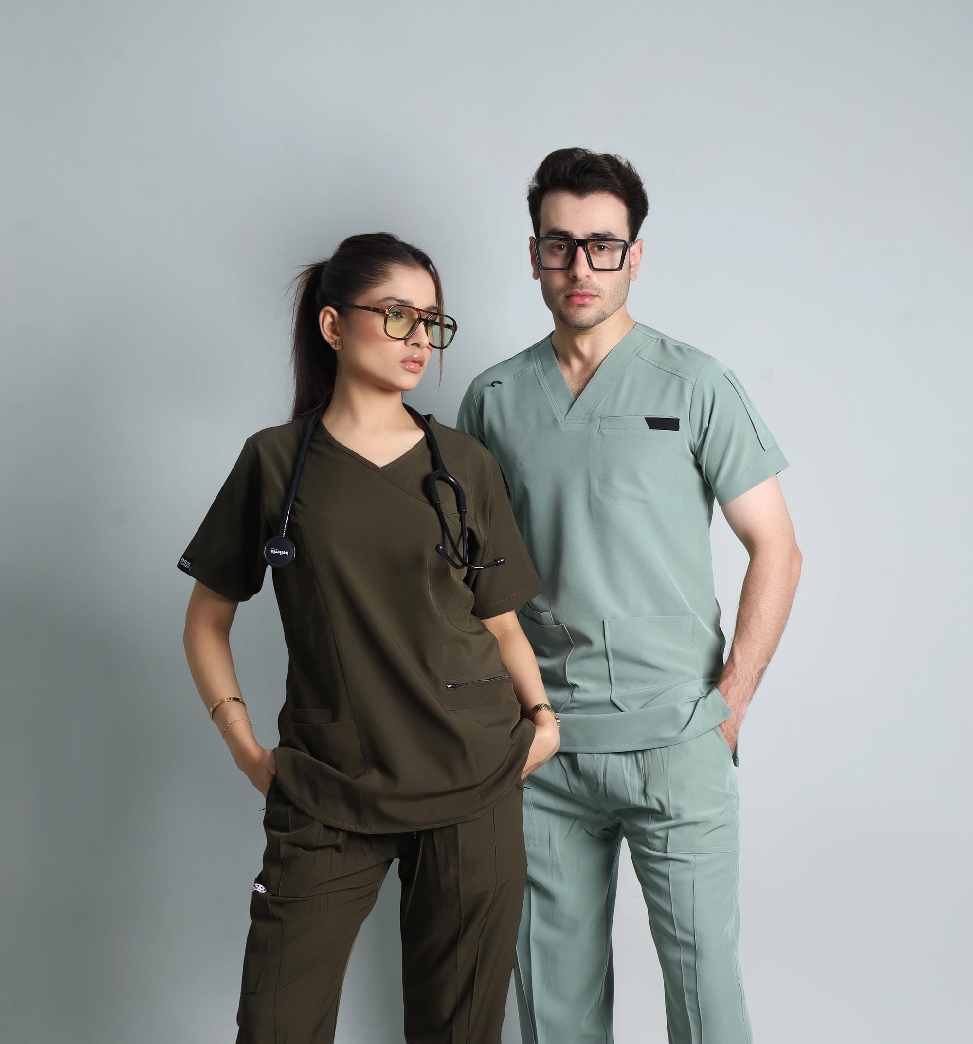 Two individuals wearing medical scrubs against a gray background
