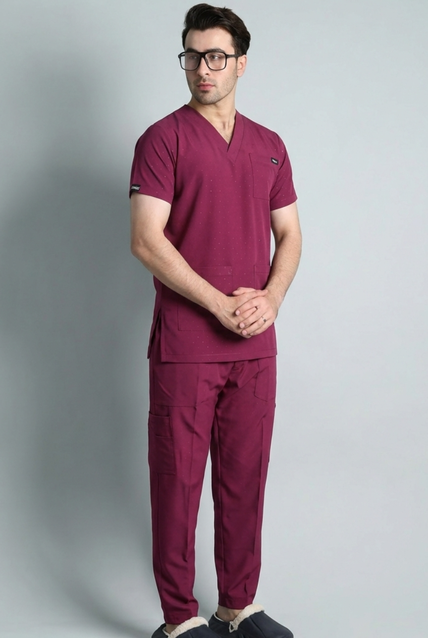 Man wearing a maroon scrub set on a gray background