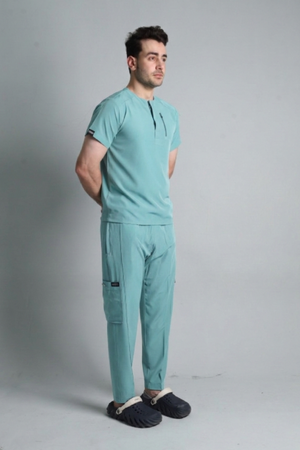 Man wearing a teal medical uniform on a gray background