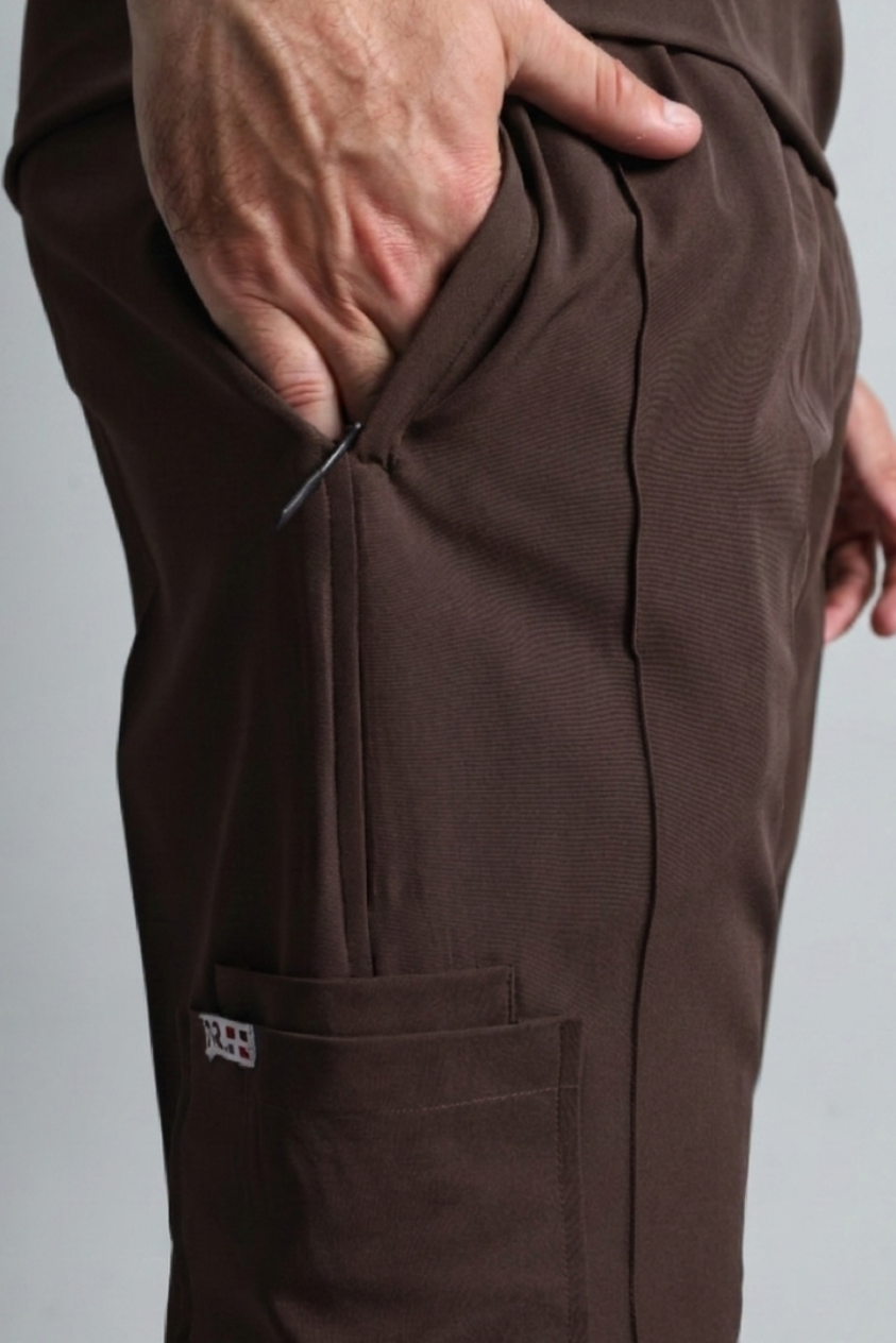 Brown pants with a hand in the pocket on a gray background