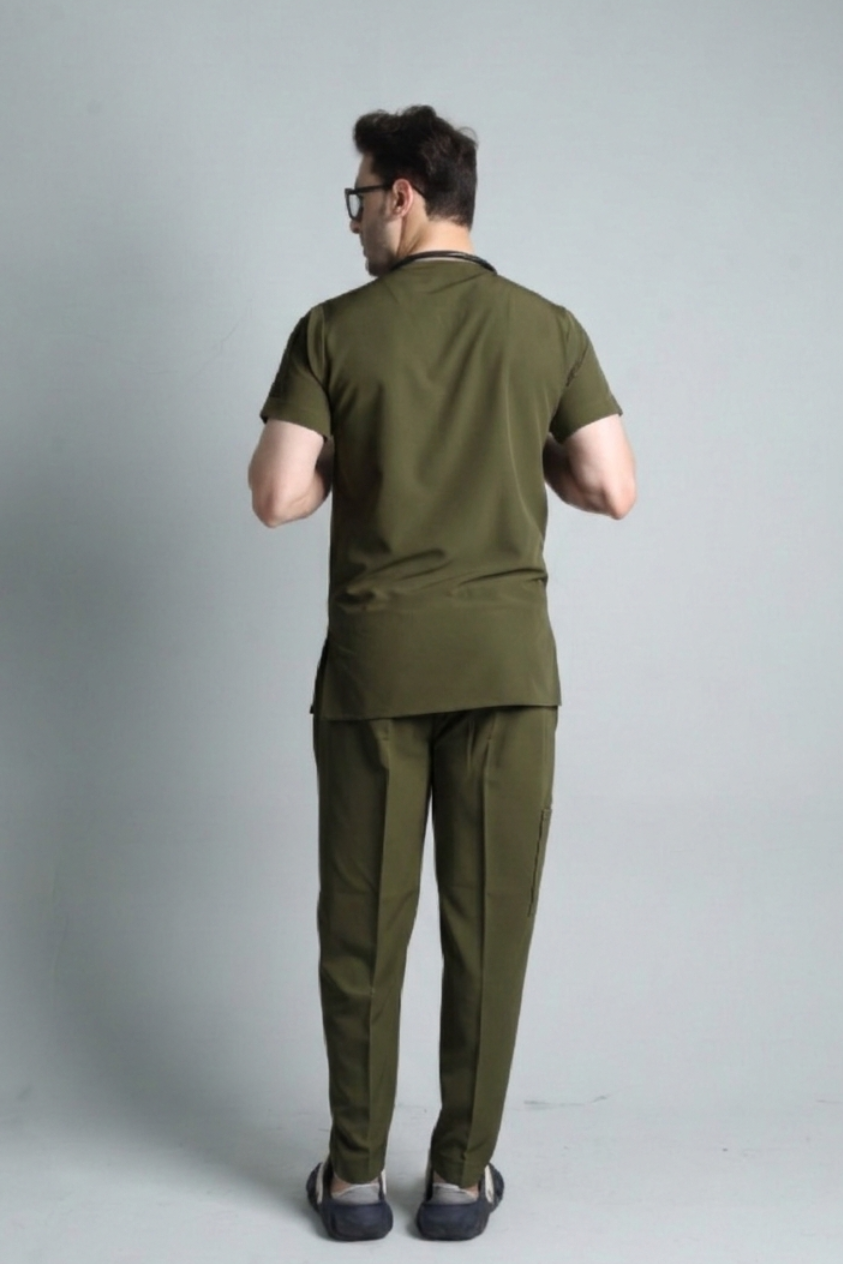 Man wearing an olive green outfit standing against a plain background