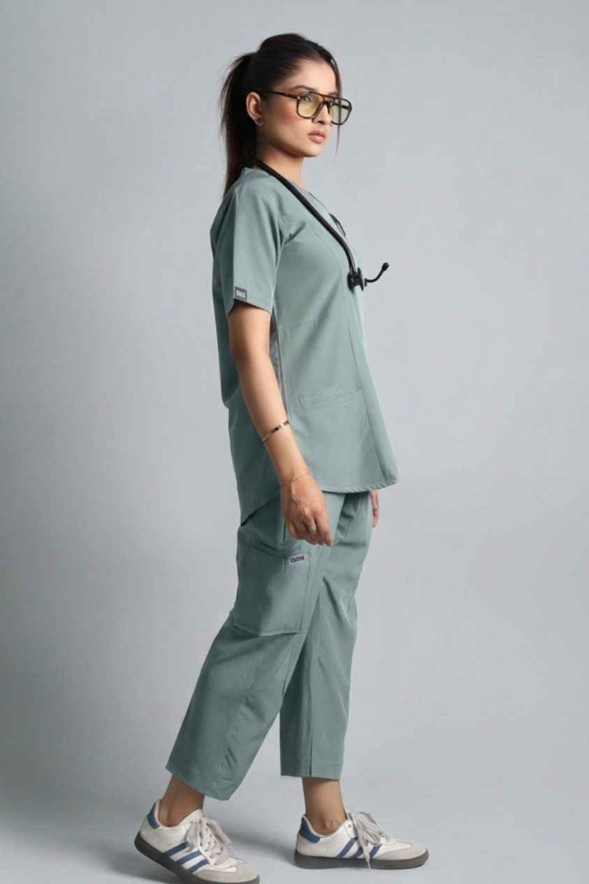 Person wearing a green medical scrub set on a gray background
