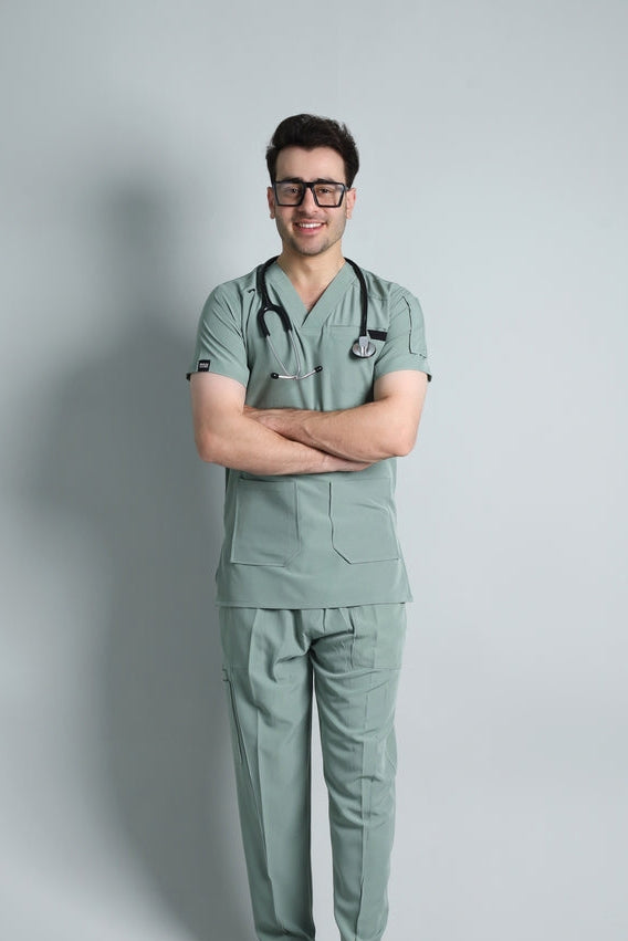 Person wearing green medical scrubs with a stethoscope on a gray background