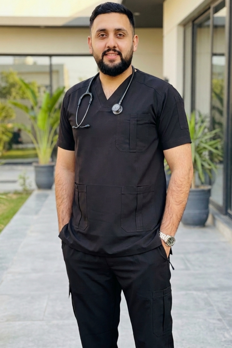 Man in black medical scrubs with a stethoscope standing outdoors.
