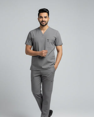 Man wearing a gray scrub set on a light gray background