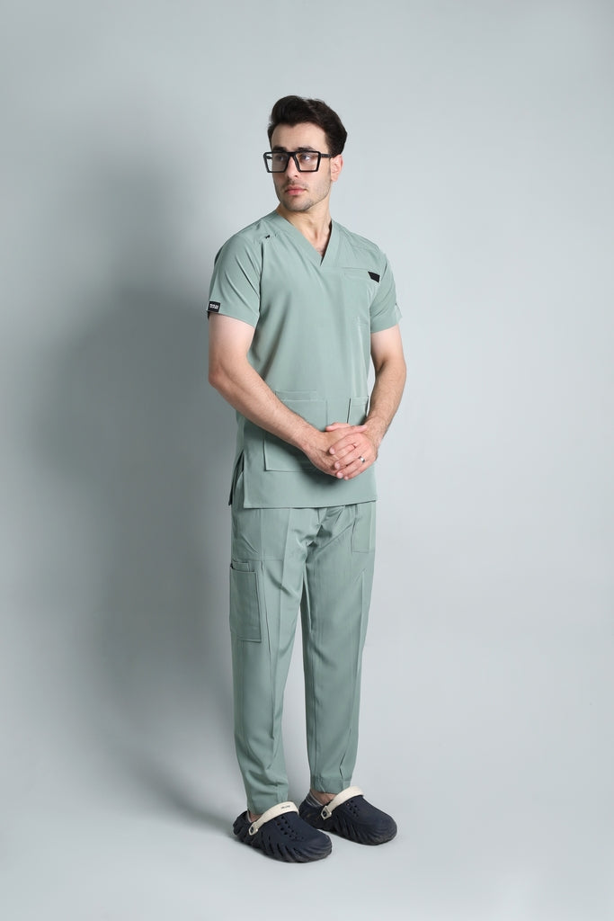 Person wearing a green medical scrub set on a gray background