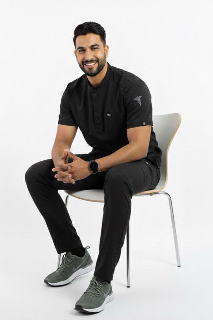 Man sitting on a chair wearing black athletic wear with a white background