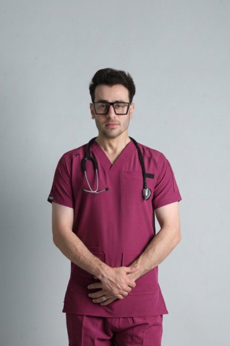 Person wearing a maroon medical scrub set with a stethoscope on a gray background