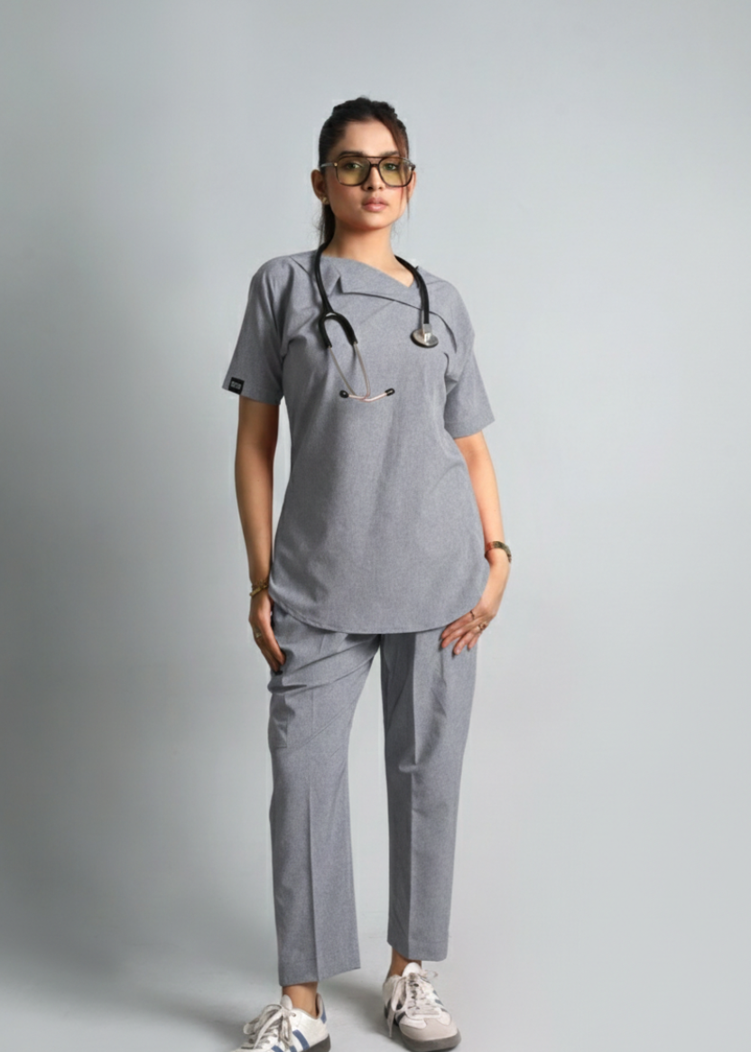 Person wearing gray medical scrubs with a stethoscope on a plain background