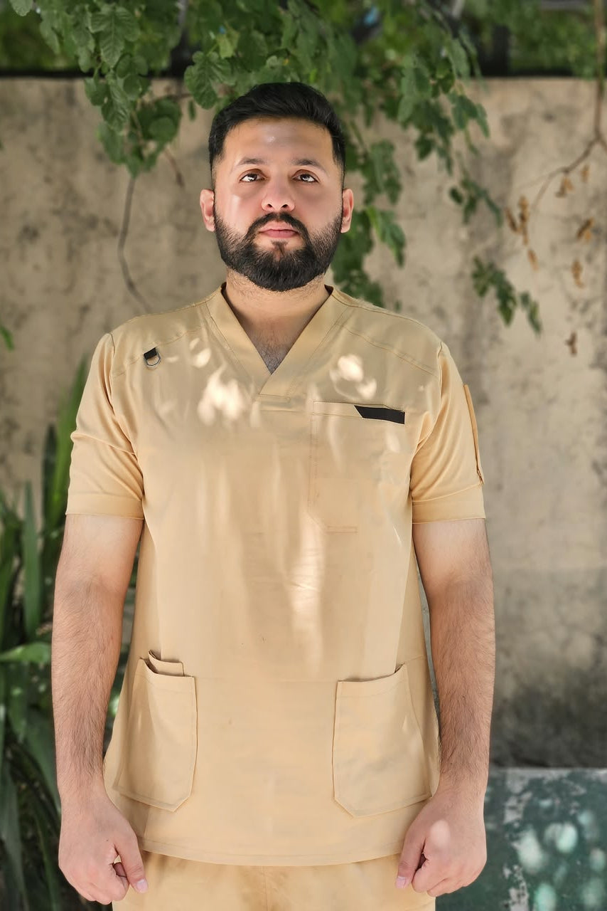 Man wearing a beige uniform standing outdoors with greenery in the background